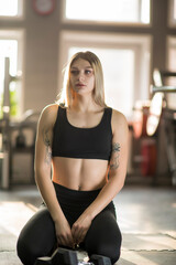 Obraz premium Young beautiful girl athlete posing in the fitness room.