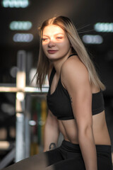 Fototapeta na wymiar Young beautiful girl athlete posing in the fitness room.