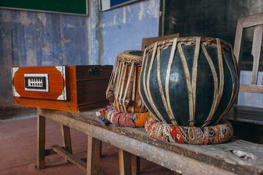 Tabla and harmonium on a bench in an old music school in asia.