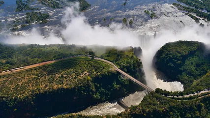 Foto op Aluminium Stunning aerial panorama view of the majestic and powerful Victoria Falls (largest waterfall worldwide) with historic bridge at the border of Zimbabwe and Zambia, Africa. © Timon