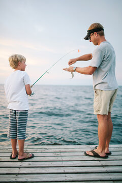 father taking his son's fish off the hook