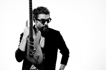 Obraz premium a man with a guitar emotions music game performance leather jacket sunglasses light background