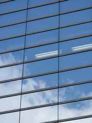 ビルの窓に映る青空と白い雲