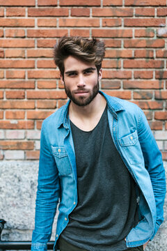 Cool Young Man with Casual Wear Against a Brick Wall