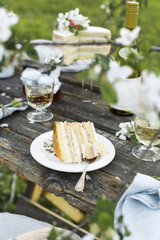 Wedding. Banquet. The chairs and table for guests, decorated with strawberry, served with cutlery, crockery and covered with a tablecloth. The table stands on a green lawn in the backyard banquet area