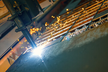 CNC plasma cutting machine cuts a metal sheet. Many sparks and incandescent drops of metal