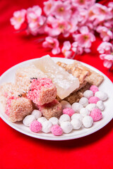 Candy comfit, Chinese sweetmeat made of many ingredientson on red background.