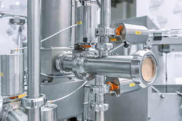 Industrial stainless steel piping connected by special nuts.