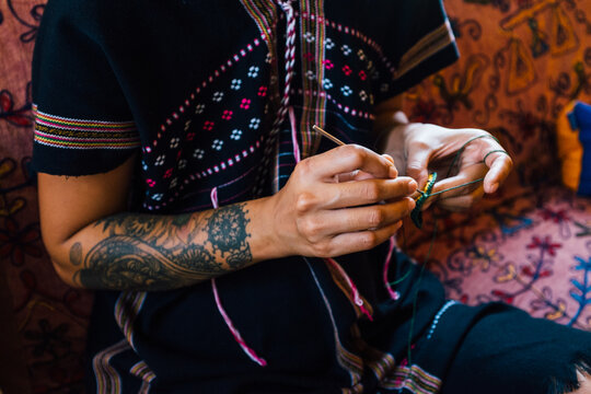 Close Up of a Tattooed Thai Woman Knitting