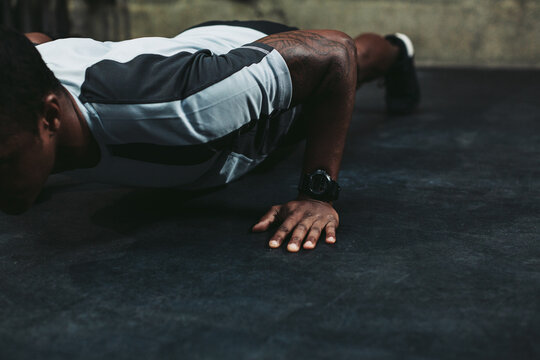 Young, fit black man training hard in fitness gym - pushups