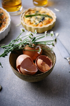 Egg shells and flowers in a stoneware bowl.