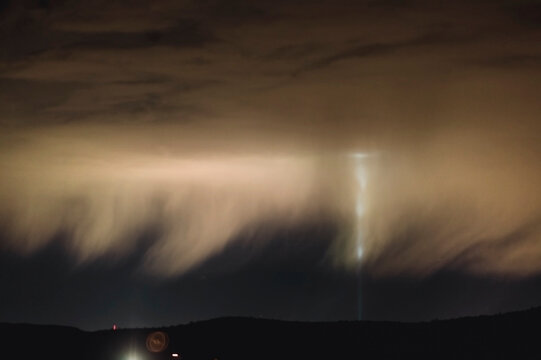 Light from the luxor reflects on rain clouds falling from the night sky