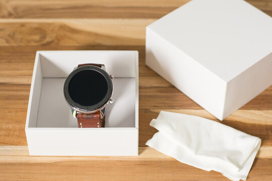 Close up cleaning modern smartwatch with microfiber cloth.