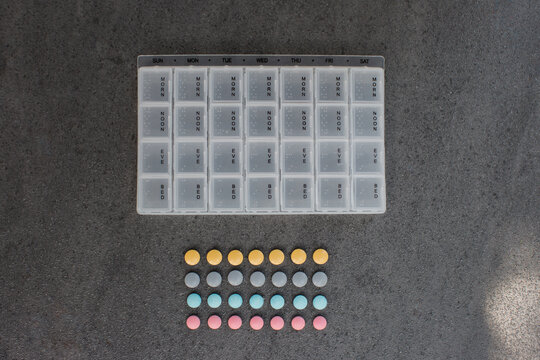 Empty Pill Case and Pills Arranged Below