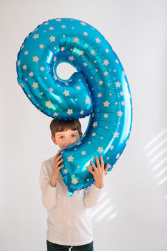 Youth holds number balloon for ninth birthday