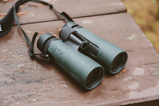 Binoculars laying on a picnic table outside