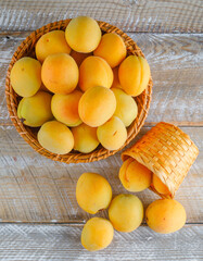 Apricots in wicker baskets on a wooden background. top view.