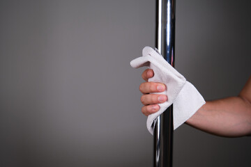 Hand cleaning a metallic pole with a cloth. Cleaning concept.