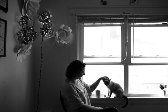 Shadowy image of woman with cat