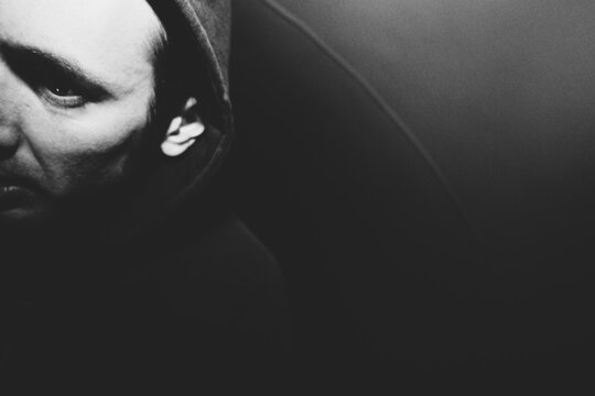 Portrait of man with surprised and disturbed face, hiding in urban tunnel