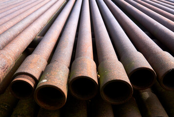 Stack of rusty tubes and drill rods for drilling
