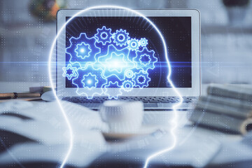 Double exposure of work space with computer and human brain drawing hologram. Brainstorm concept.