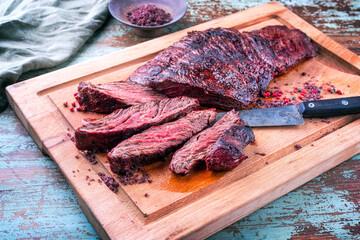 Barbecue wagyu bavette beef steak with red wine salt offered as close-up on a rustic wooden board