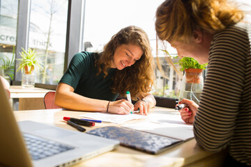 Two young women working, sketching and designing.