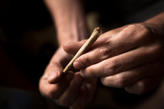 Close up of Hands of a man rolling a joint.