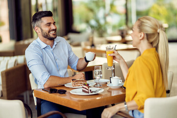 Happy couple having fun while talking and enjoying in a cafe.