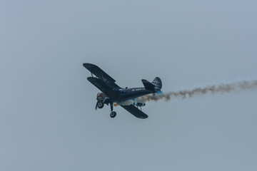 biplane plane with smoke at a air show