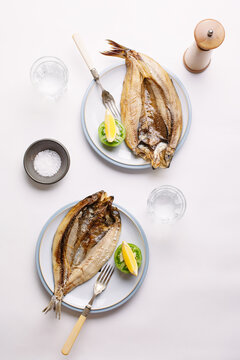 Grilled fish on plates with lemon.