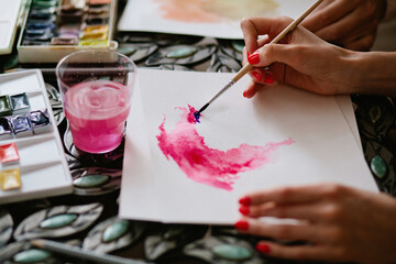 Unrecognizable female doing watercolors sample