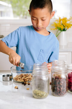 Healthy young boy preparing nuts and frutis