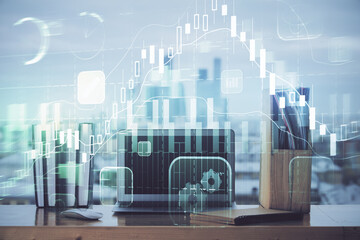 Stock market graph on background with desk and personal computer. Double exposure. Concept of financial analysis.