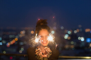 Happy caucasian woman holding sparklers