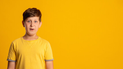 Excited kid. Special offer. Wow reaction. Dream opportunity. Portrait of surprised amazed happy young boy isolated on orange copy space background.