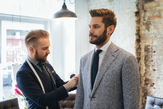Men's Fashion - Young Caucasian Tailor Adjusting Suit of Young Caucasian Customer