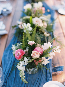 blue runner on table with pink floral centerpiece