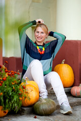 Fototapeta premium mature woman on the porch of a house with columns in autumn