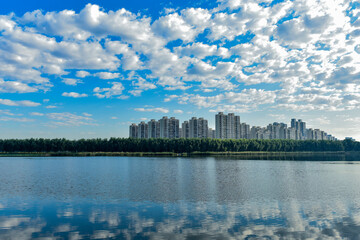 Fototapeta premium Blue sky and white clouds in the background of waterfront city skyline scenery, LUANNAN COUNTY, Hebei Province, China.