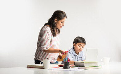 Online school in India concept - Cute little son taking mother's help in studies or homework