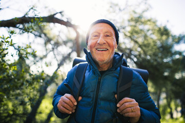 Portrait of a hiker senior man smiling in the woods.