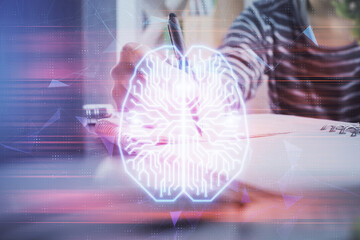 Multi exposure of writing hand on background with brain hologram. Concept of self learning.