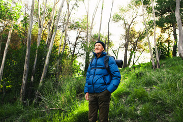 Adventurer senior man standing in the woods.