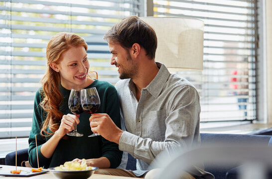 Happy Loving Couple Toasting Wine In Restaurant