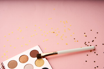 makeup brushes and eyeshadow professional cosmetics on pink background