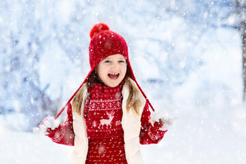Child playing in snow on Christmas. Kids in winter