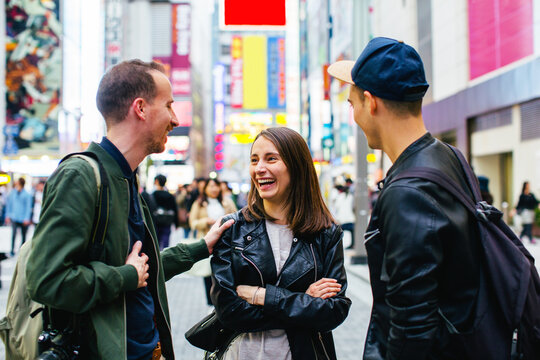 Happy tourist friends talking in Tokyo street.