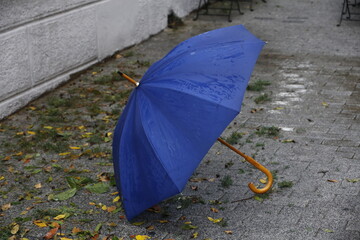 Blue umbrella standing on wet street on a rainy day